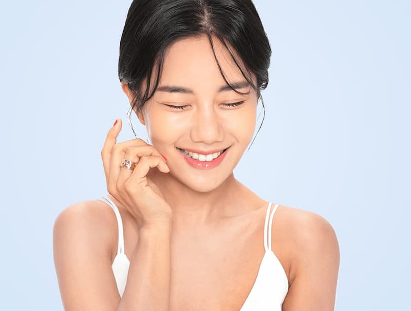 Youthful Korean woman smiling with a natural hydrated glow