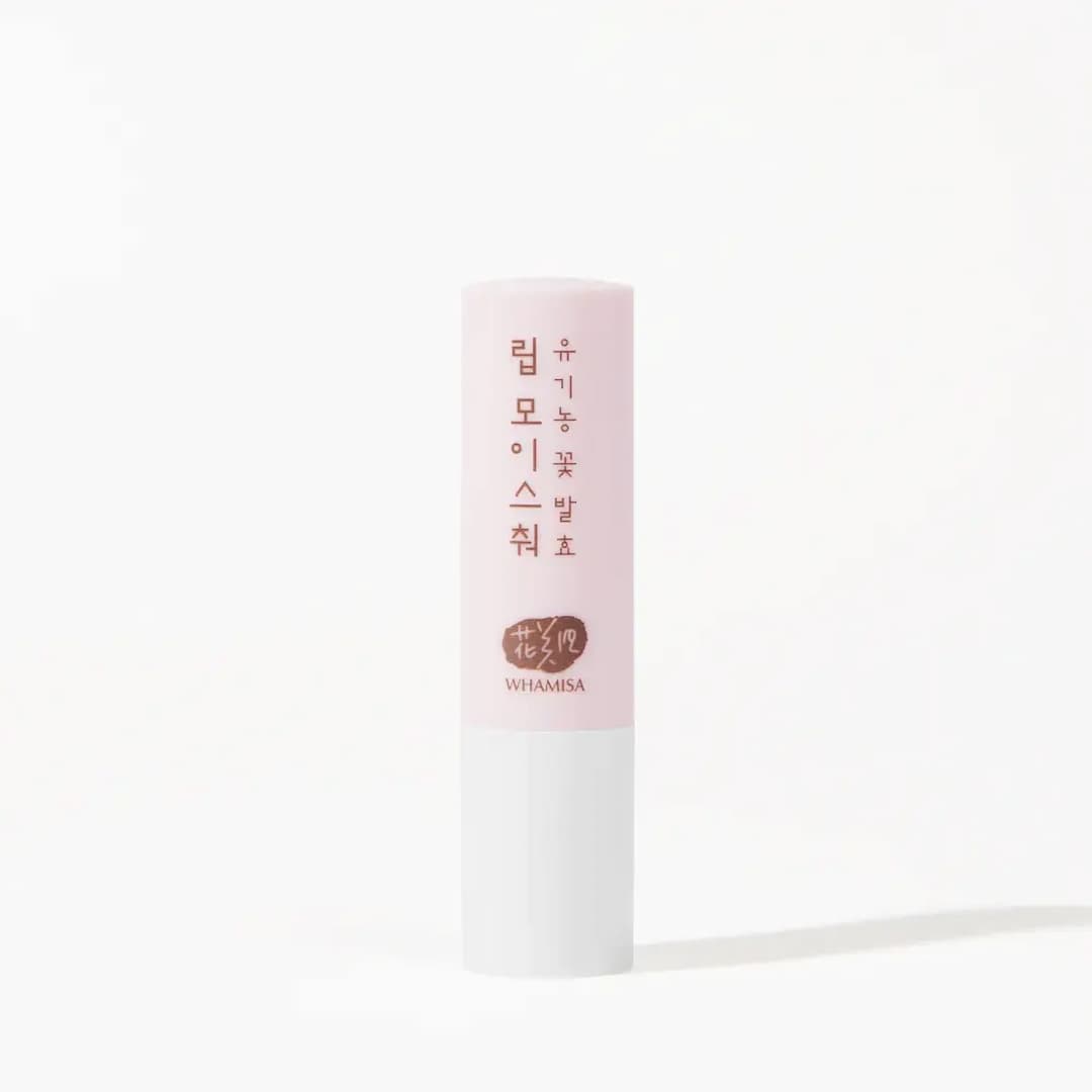 A single stick of Whamisa Organic Flower Lip Balm standing upright against a white background