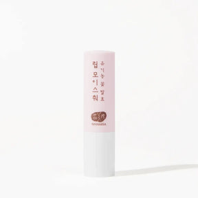 A single stick of Whamisa Organic Flower Lip Balm standing upright against a white background