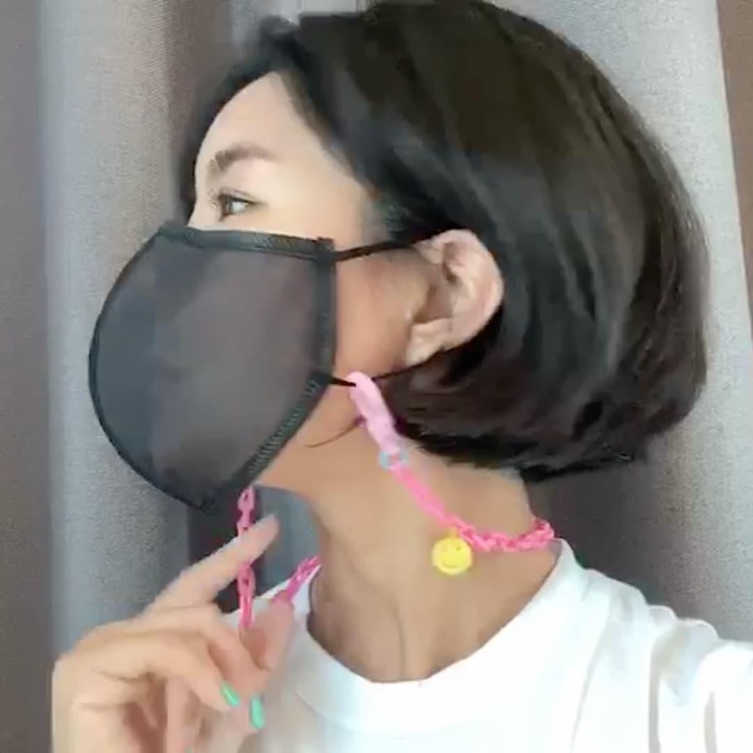 Side profile of a model wearing the translucent mask - with pink mask strap